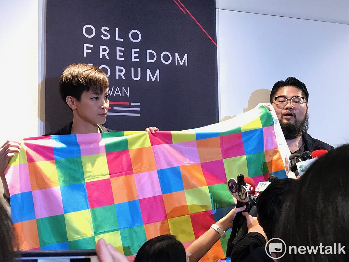香港民運歌手何韻詩（左）與中國異議藝術家巴丟草（右），並一同展示由巴丟草設計代表香港精神的「連儂牆旗」。 圖：周煊惠 ／攝