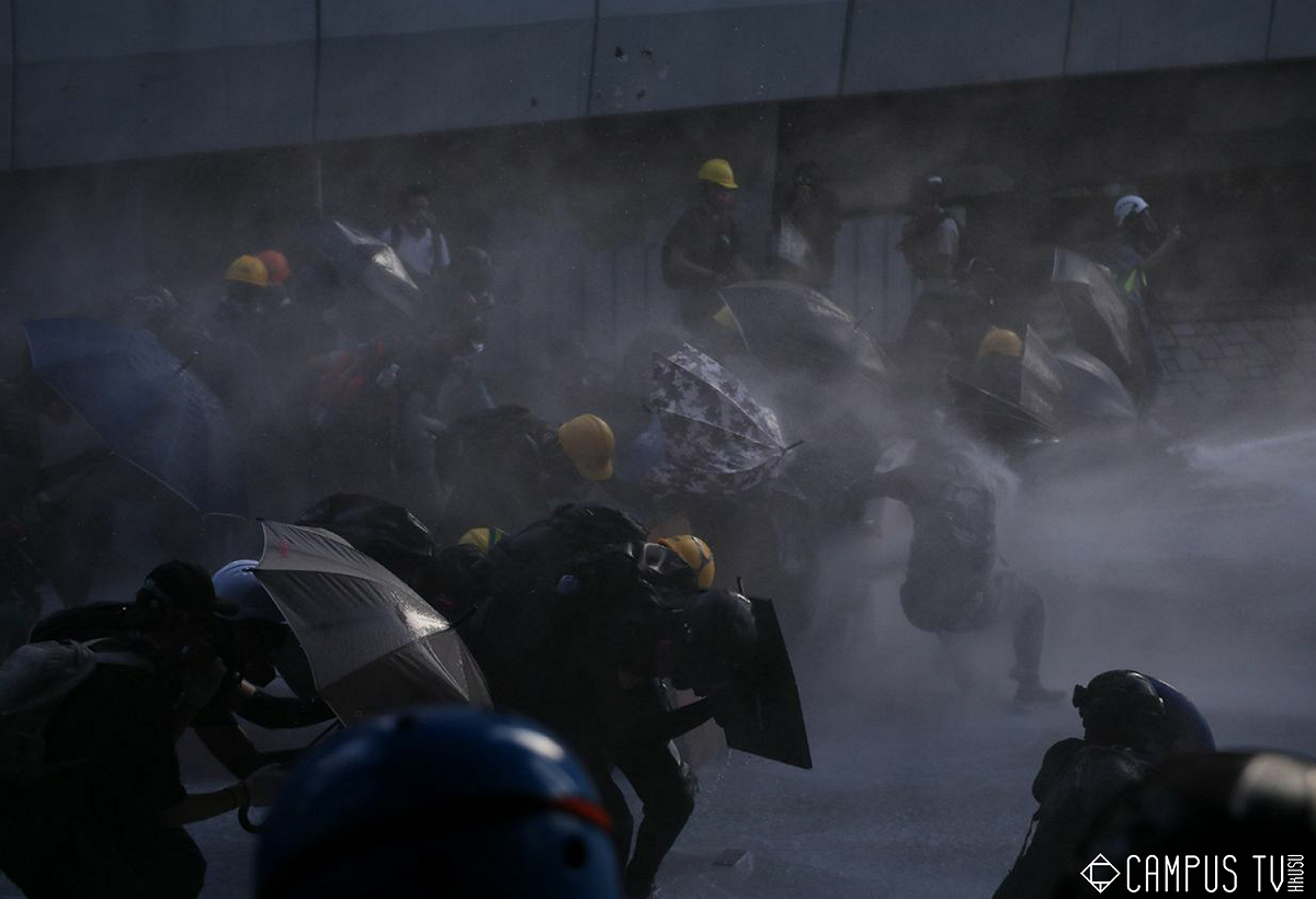 面對水砲車的攻擊，現場的港民只能趕緊開傘保護自己。 圖：翻攝自香港大學學生會校園電視臉書
