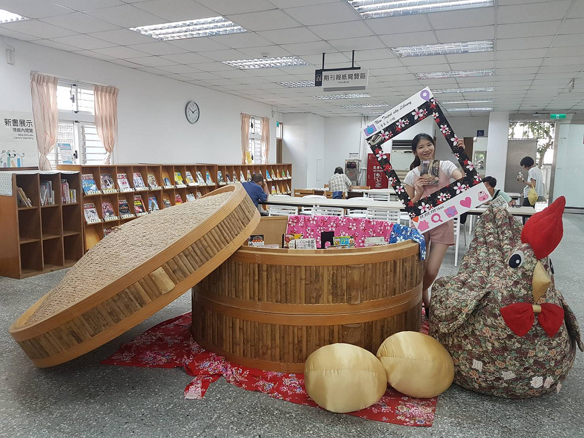 新北市立圖書館三重東區分館出現超巨大蒸籠和一隻布雞，路過民眾紛紛拍照留念。 圖：新北市政府／提供