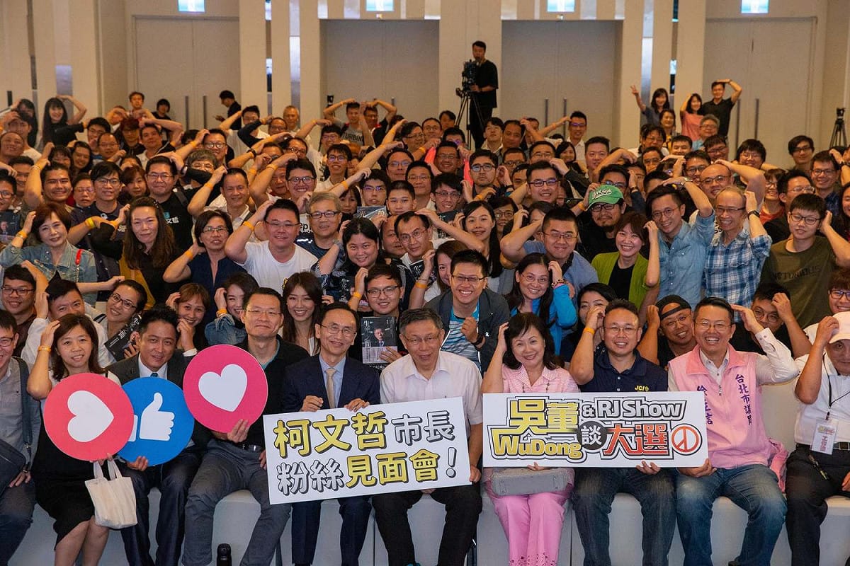 柯文哲桃園中壢與粉絲合影，粉絲擺出他抓頭的招牌動作。 圖：翻攝柯粉俱樂部臉書
