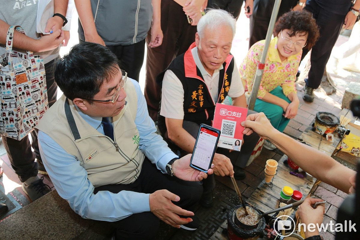 台南孔廟商圈府中街假日創意市集成為全國首條具有行動支付示範市集街道。台南市長黃偉哲出席「全台首創—孔廟商圈假日市集 行動支付一條街」記者會，親身體驗行動支付的便利性。 圖／黃博郎攝