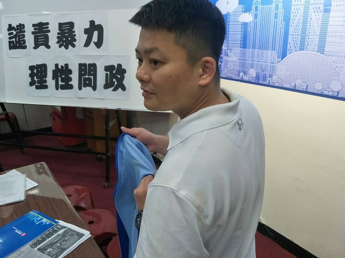 曾俊傑向媒體秀出染有咖啡漬的背心。 高雄市議會國民黨團