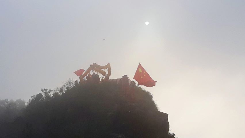 照片中有人在山脊舉五星旗舞龍。 圖：翻攝自Hong Kong Autonomy Action - 香港自治行動臉書