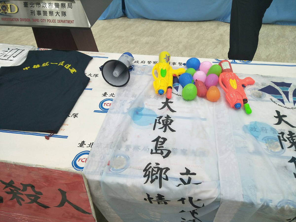 警方搜查新北市某處所時，查獲統促黨識別以及水槍、水球、廚餘、旗幟、標語、大聲公、名片、背心等相關證物。 圖 : 北市警局提供