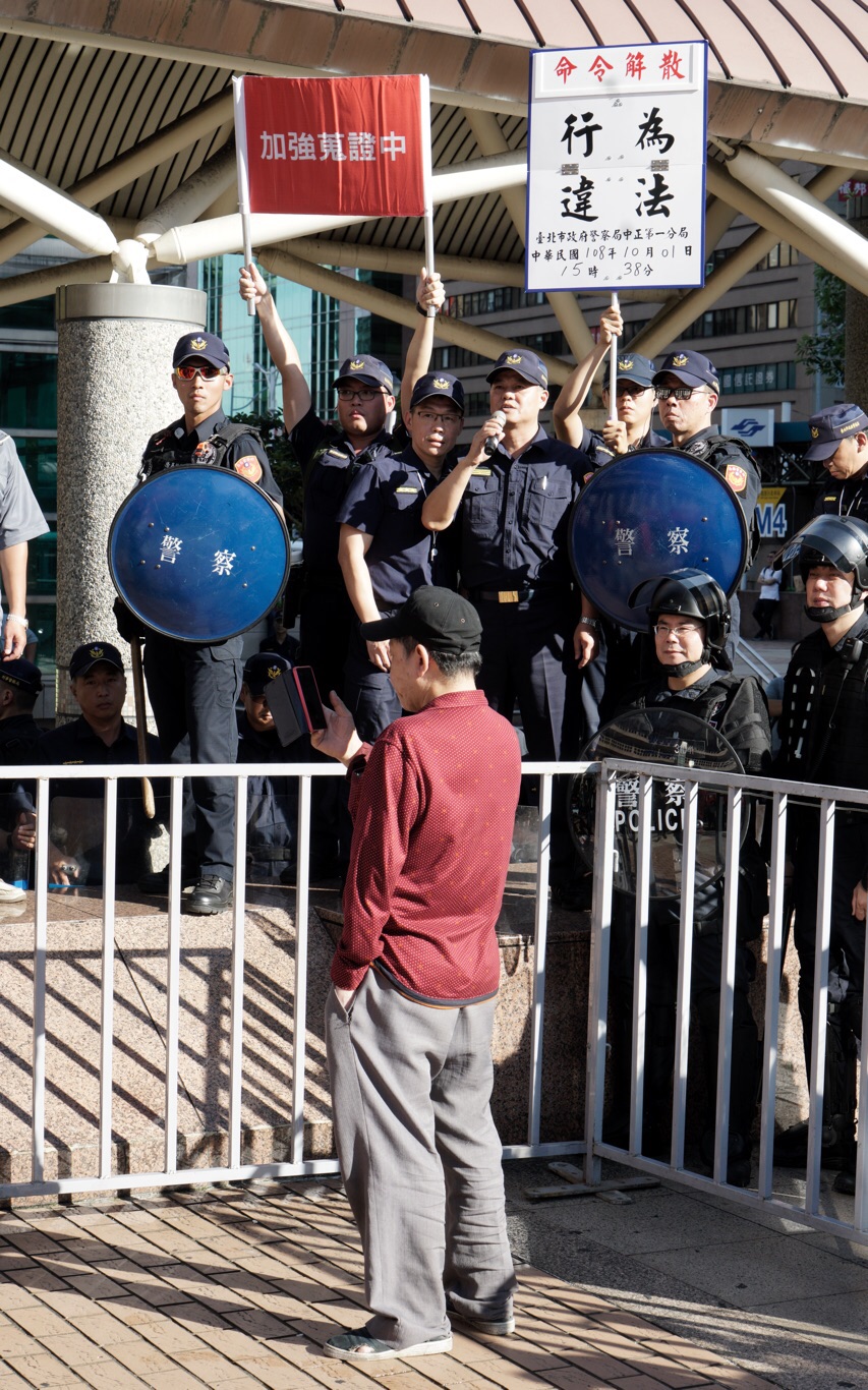 警方現場進行蒐證、並舉牌制止。 圖：張良一／攝