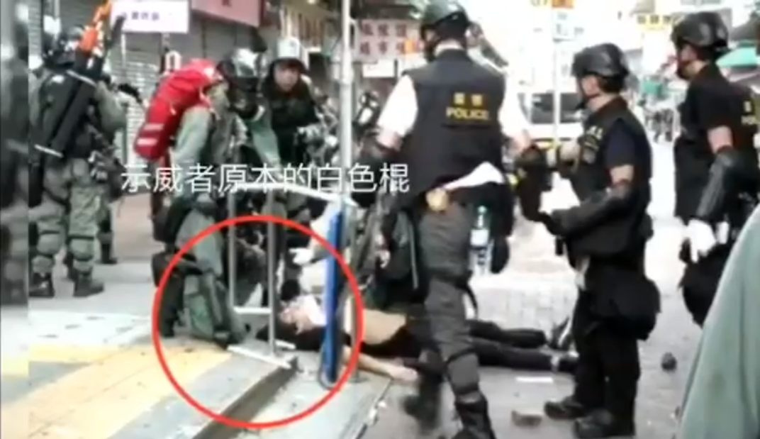 示威者受傷倒地後，原本持有的白色桿子遺落在旁，未被警員取走。 圖 :	翻攝自桑普臉書影片