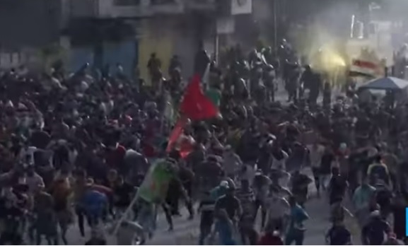 數以千計的伊拉克民眾不顧實彈和催淚瓦斯威脅走上街頭，至少造成19人死亡、400多人受傷。 圖：翻攝Youtube