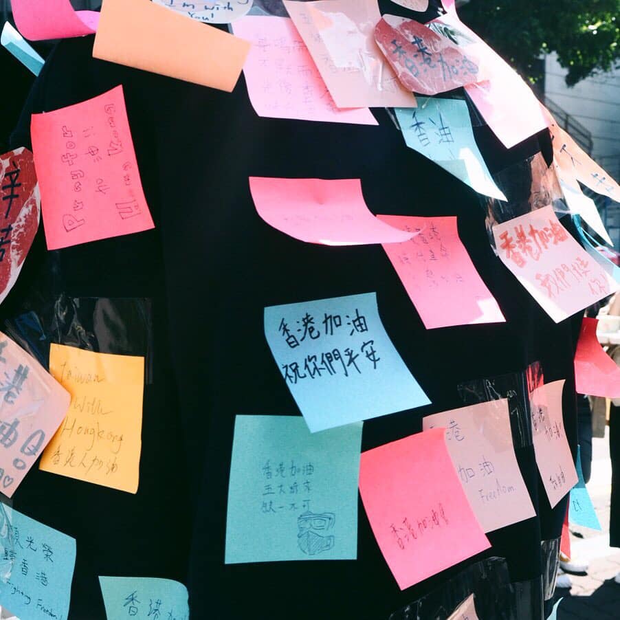 許多學生紛紛在「連儂人」身上貼上許多加油便利貼，期盼大家一起關注香港反送中話題。 圖：翻攝自不禮貌鄉民團臉書