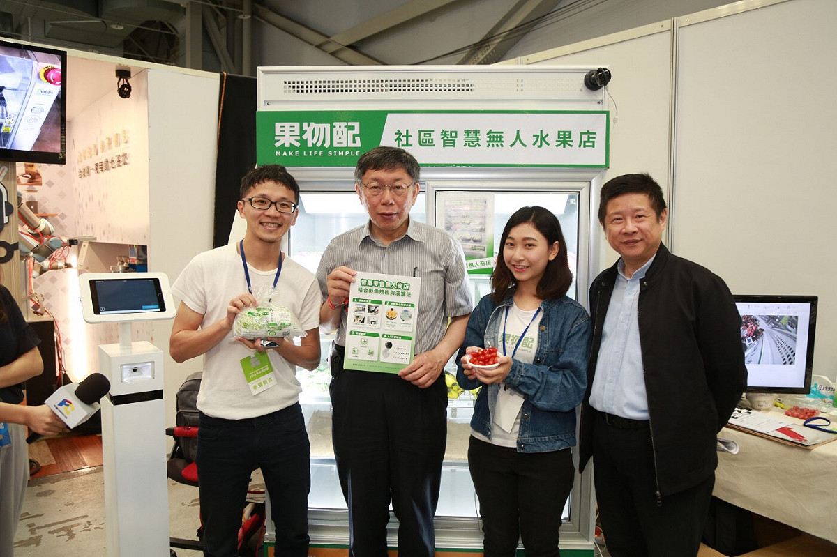 果物配參加 2018 年未來商務展，執行長張智翔（左一）與台北市長柯文哲（左二）介紹「無人水果店」。 圖：果物配／提供