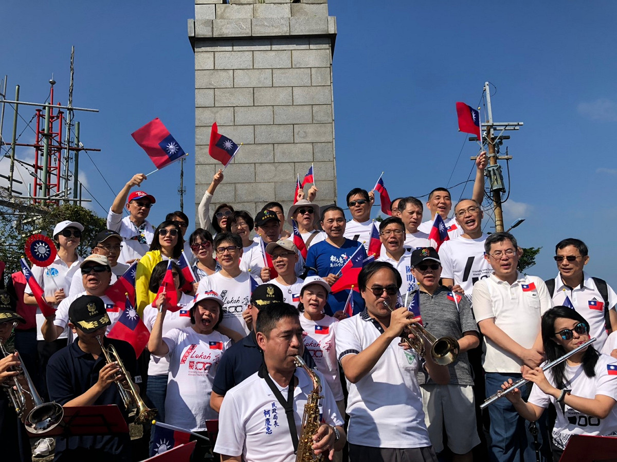 侯友宜及市府團隊攀登硬漢嶺，登頂後大家一起揮舞千面國旗，並在自備樂器演奏下，高唱國旗歌展現愛國心。 圖：新北市民政局提供
