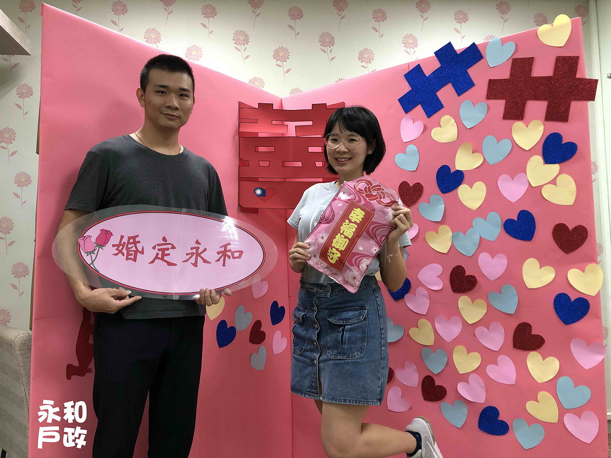 永和戶所則製作大型立體「囍」字賀卡，並提供國旗圍巾、國旗扇讓新人拍照，還有幸福御守「喜米」的甜蜜小禮。  圖：新北市民政局提供