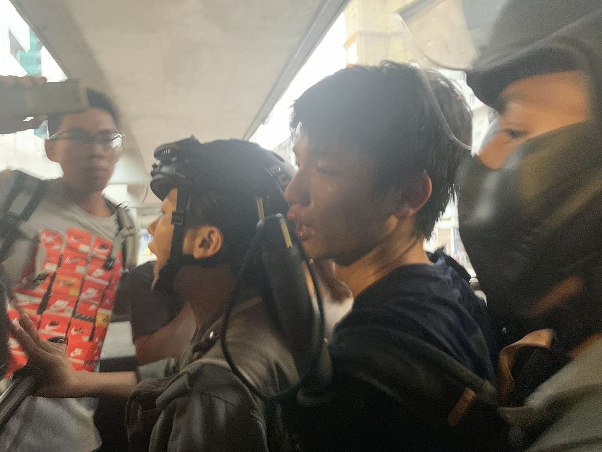一名員警在觀塘apm出口通道遭一名黑衣示威者以刀割傷後頸，其後遭到警方制服逮捕。 圖：擷取自香港01