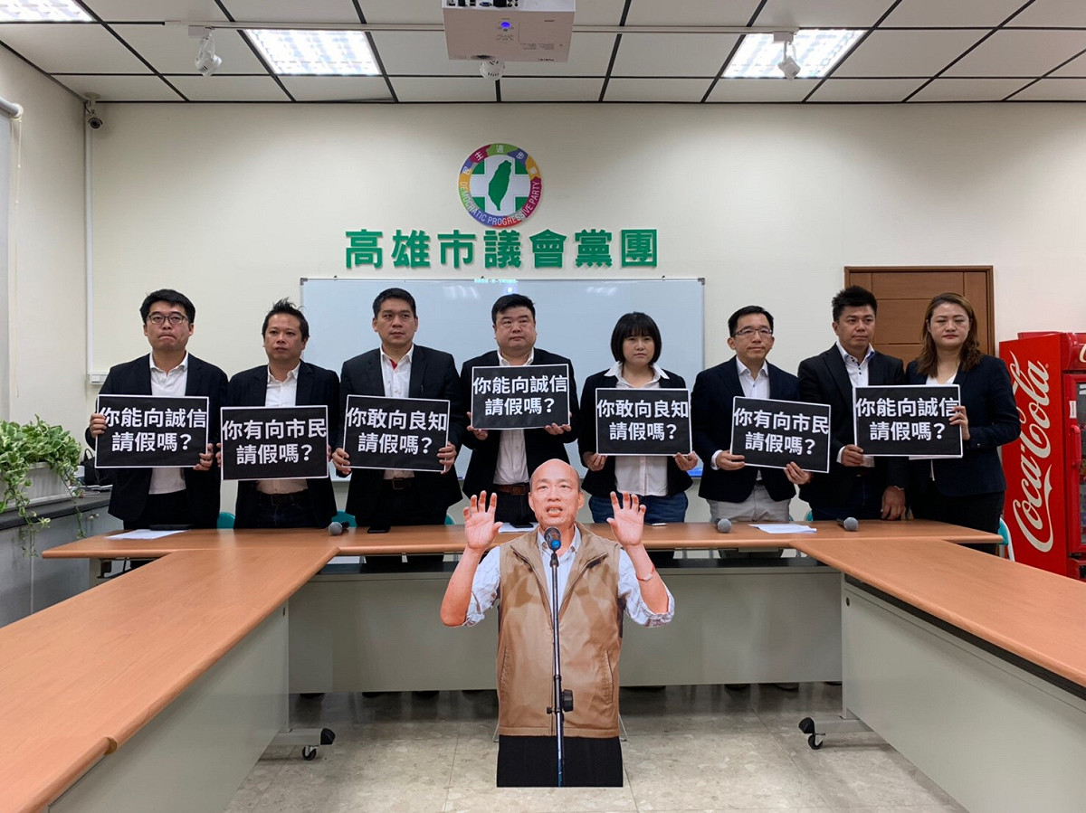 高雄市議會民進黨團召開記者會，質疑高雄市長韓國瑜不敢向市民請假拚大選，沒有誠信、良知。中間還嘲諷地放個韓國瑜的「人形立牌」。 圖：高雄市議會民進黨團提供