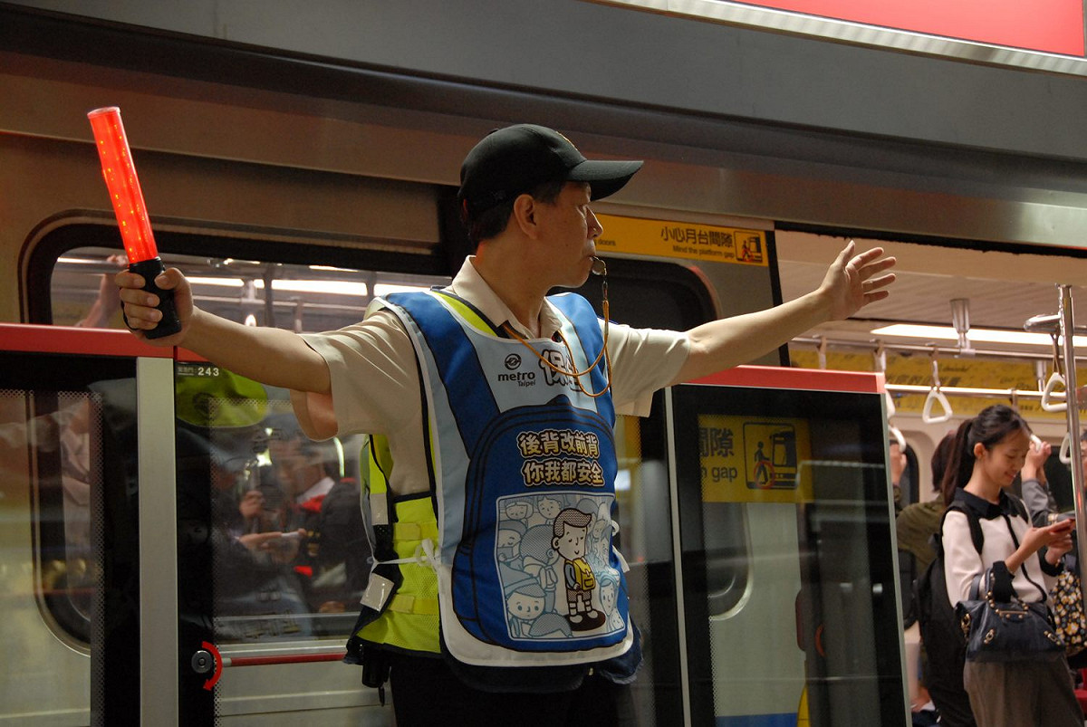 近日北捷開始乘車禮儀第二波擴大宣傳，全線車站的保全及清潔人員，將於尖峰時段人潮眾多的時候，穿起印有標語的背心。 圖：台北市政府／提供