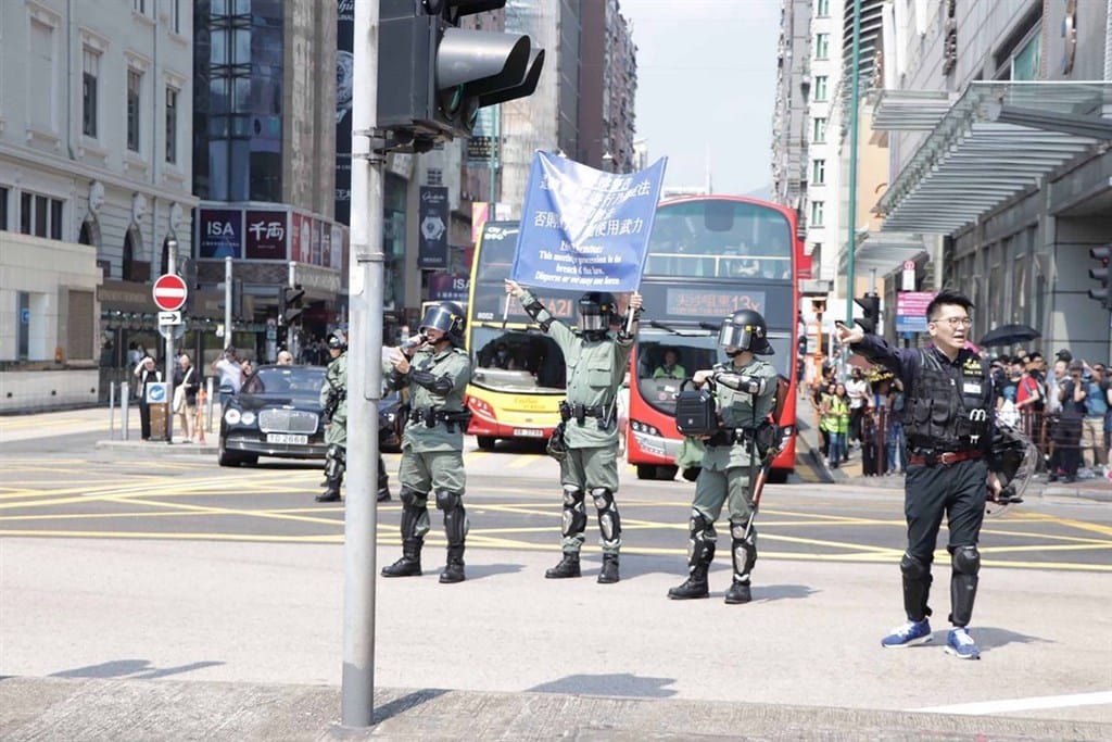 香港民間人權陣線原定20日下午在尖沙咀發起遊行，但日前遭警方否決。中午12時30分左右，仍有大批市民陸續到集合地點文化中心附近，準備自行響應遊行。圖為遊行出發前，警方在現場舉起藍旗，警告這是非法集會。 圖：中央社
