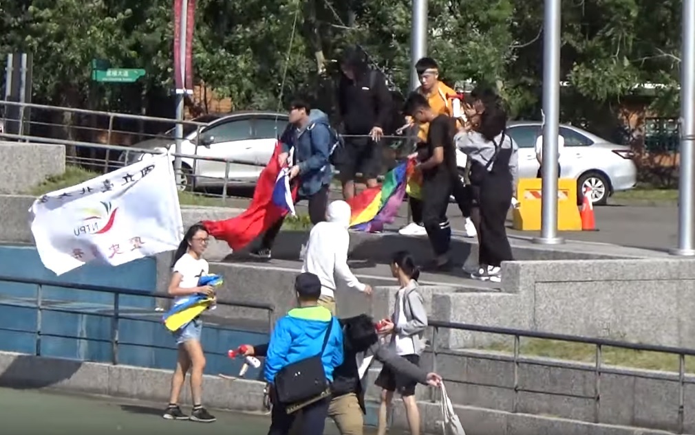 國立台北大學三峽校區26日舉行校慶運動會，有學生為抗議學校規定校慶要點名，在播放國旗歌時衝上台將國旗撤換為「彩虹旗」。 圖:翻攝自Youtube