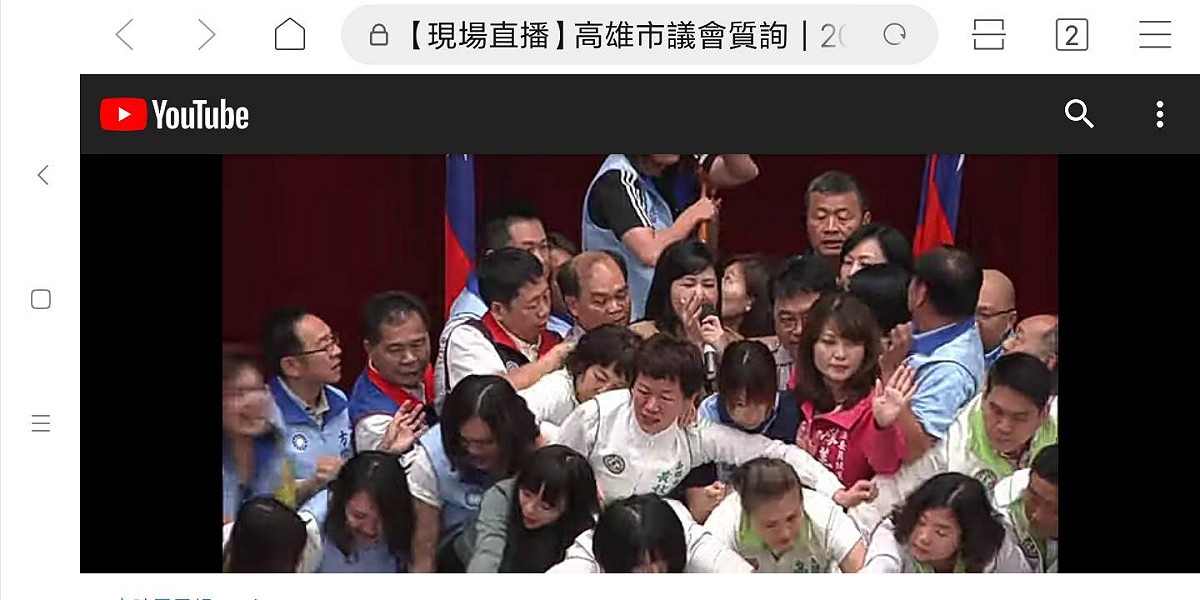 藍綠議員在主席台擠成一團，國民黨議員劉德林遭推倒頭破血流。 圖 : 高雄市議會現場直播畫面