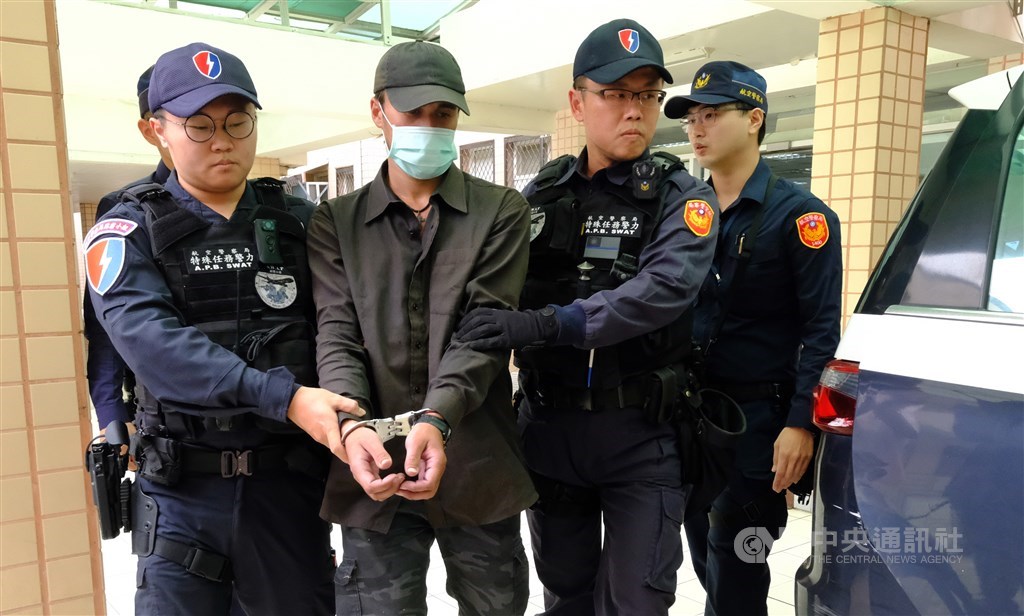 桃園國際機場2日發生一名外籍男子闖入管制區，並爬上準備起飛的華航班機起落架，男子（左2）3日上午從航警局押解到桃園地檢署時不發一語。 圖/中央社