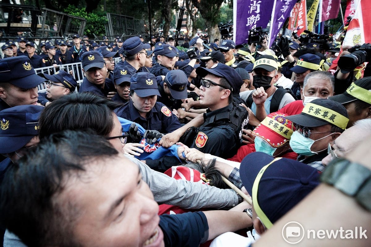 頭綁「警察尊嚴」布條的退警和現役警察在行政院外爆發激烈的推擠衝突。 圖：張良一／攝