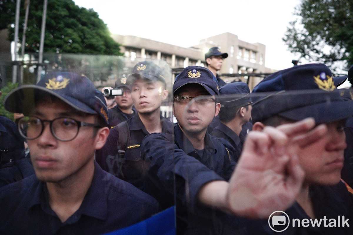 警方在行政院外架拒馬並高舉盾牌防止退警衝進行政院。 圖：張良一／攝