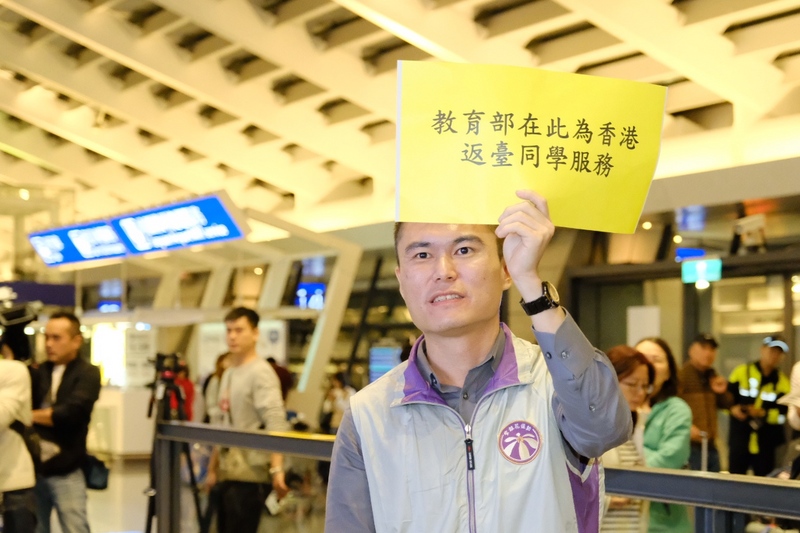 在香港的台北經濟文化辦事處協助下，香港中文大學71名台灣學生在14日凌晨抵台。教育部人員在接機大廳高舉海報，同時表示，若學生14日沒有交通工具可以返家，教育部也提供免費住宿。 圖：中央社提供