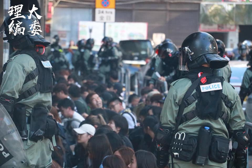 香港警察18日上午在理工大學附近的尖東南洋中心外攔查，逮捕超過50名市民，並以束帶反綁他們雙手。 圖：翻攝自理大學生報編委會臉書