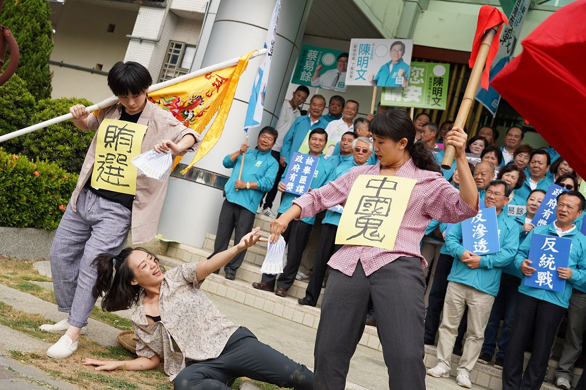 陳明文及蔡易餘今天上午一起到選委會登記，競選團隊在選委會外演出行動劇「抓中國鬼反賄選」。 圖：陳明文競選團隊/提供