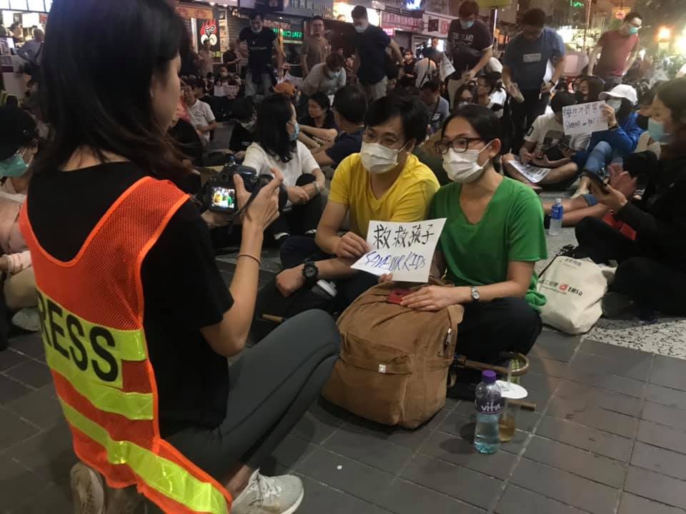 在外靜坐的家長手持紙牌，寫著「入理大救孩子」、「救救孩子，我不自殺」。 圖：翻攝張潔平臉書