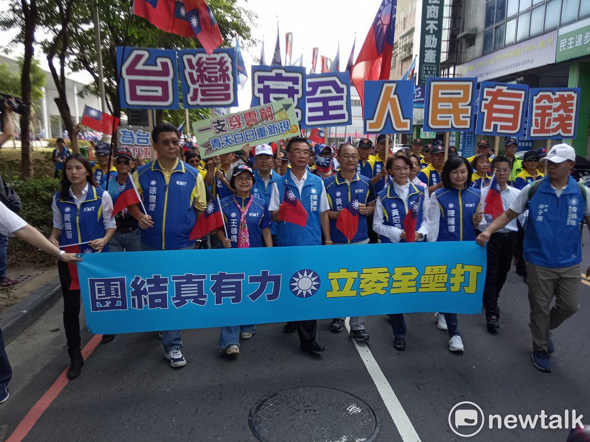 國民黨立委候選人帶著支持者從鳳山行政中心走向選委會，準備辦理登記。 圖：孫家銘／攝
