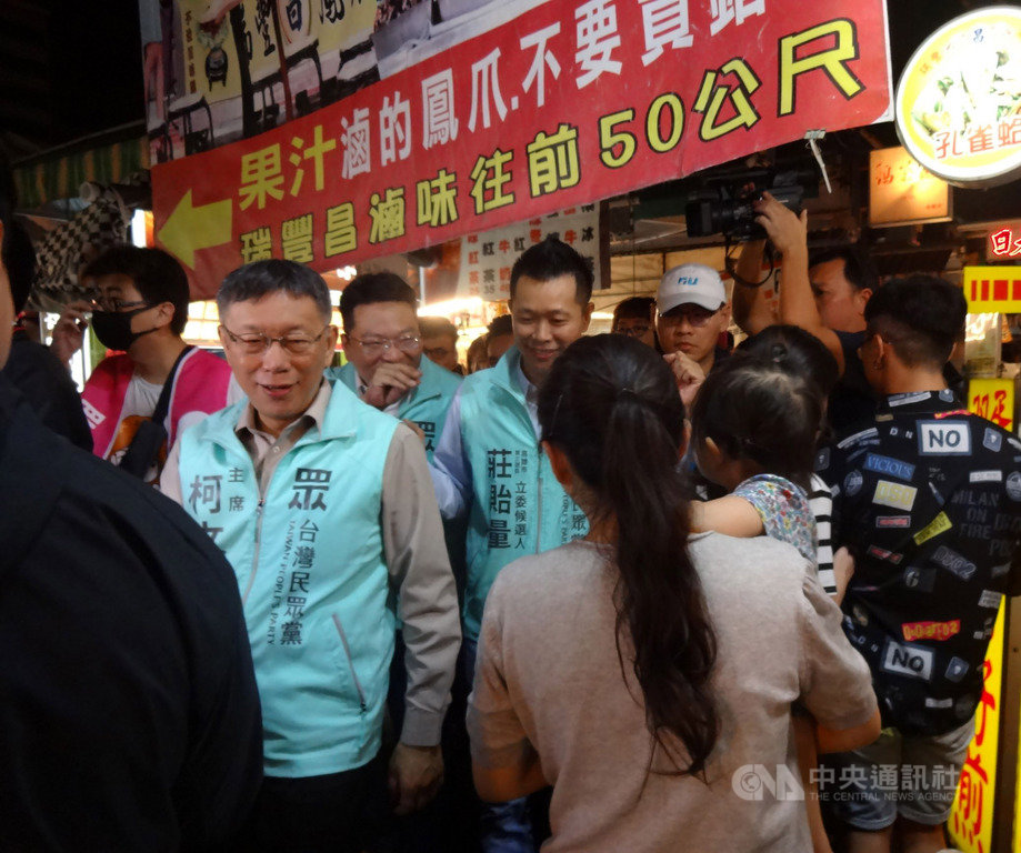 台灣民眾黨主席柯文哲（前左）23日晚間走訪高雄瑞豐夜市，為黨提名立委參選人掃街助選，並與民眾近距離互動，力拚支持。 圖／中央社提供