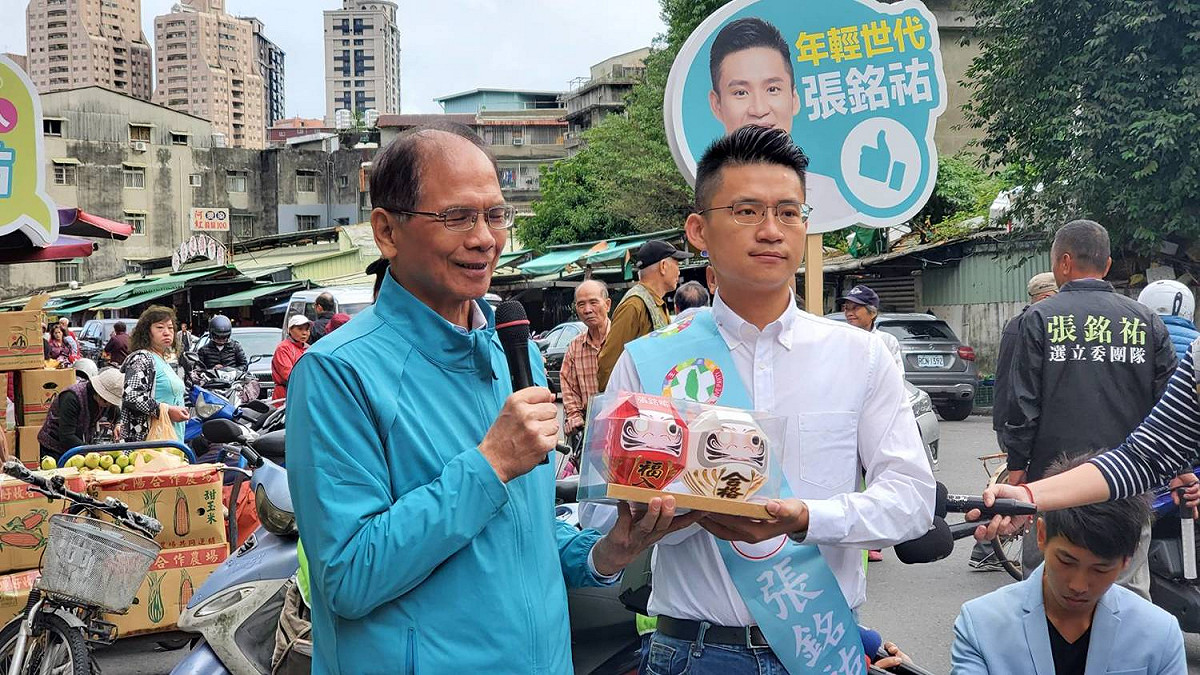 前行政院長游錫堃擔任民進黨「護國保台」助選團團長，今（26）天特別到新店區陪同黨提名立委參選人張銘祐到仁愛市場掃街拜票，並送給張銘祐「必勝達摩」吉祥物。 圖：張銘祐競選辦公室提供