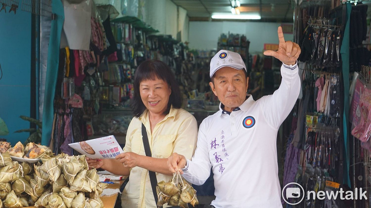 林義豐人氣不減，拜票時不忘比出其招牌手勢。 圖：黃博郎／攝