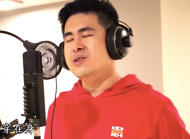王炳中穿著自己販售的兩岸統一衣服唱歌推銷。 圖：翻攝自綠黨臉書