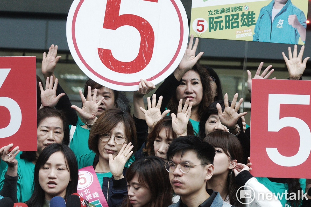 民進黨立委候選人的工作人員用手勢比出立委候選人的號次。 圖：張良一/攝
