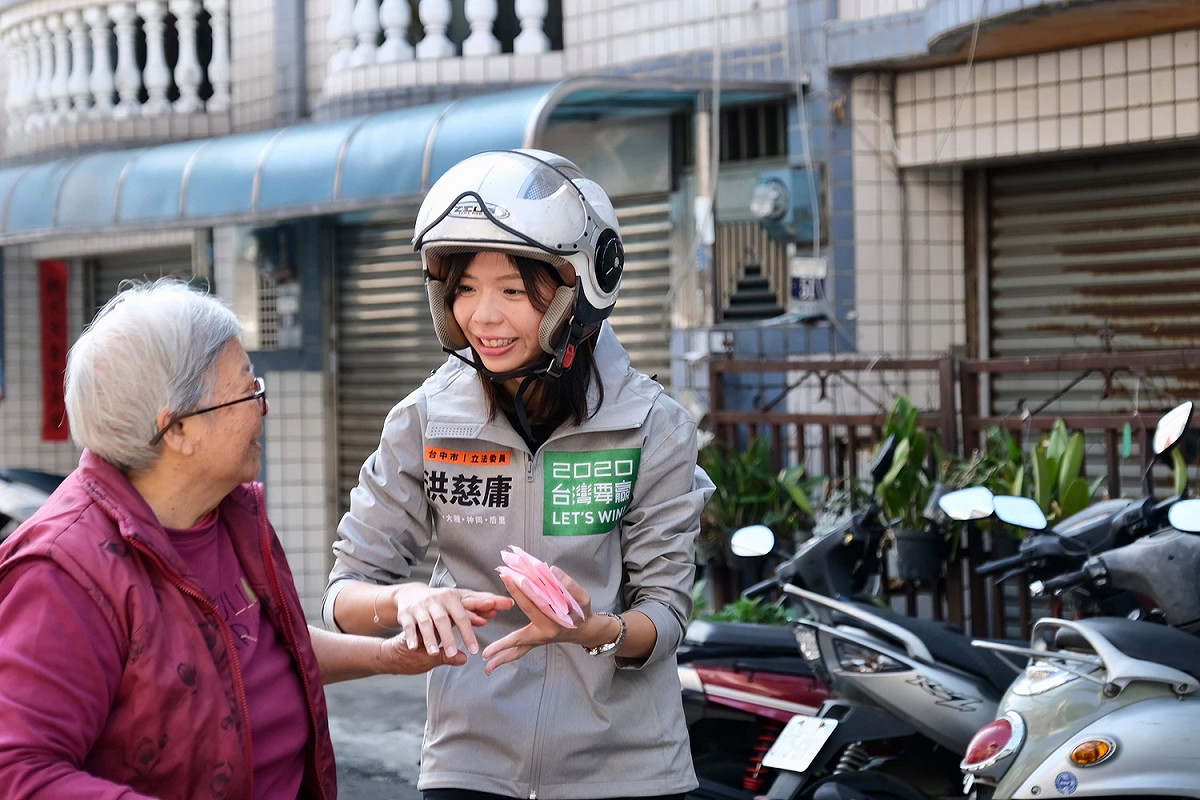 騎歐兜邁「追垃圾車」拜票，洪慈庸偕同夫婿卓冠廷和鄉親搏感情。 圖：洪慈庸辦公室／提供