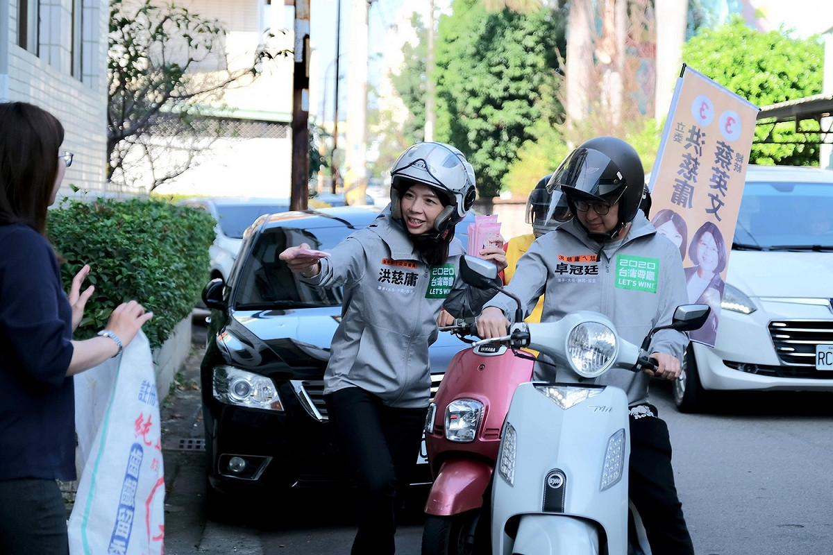 騎歐兜邁「追垃圾車」拜票，洪慈庸偕同夫婿卓冠廷和鄉親搏感情。 圖：洪慈庸辦公室／提供