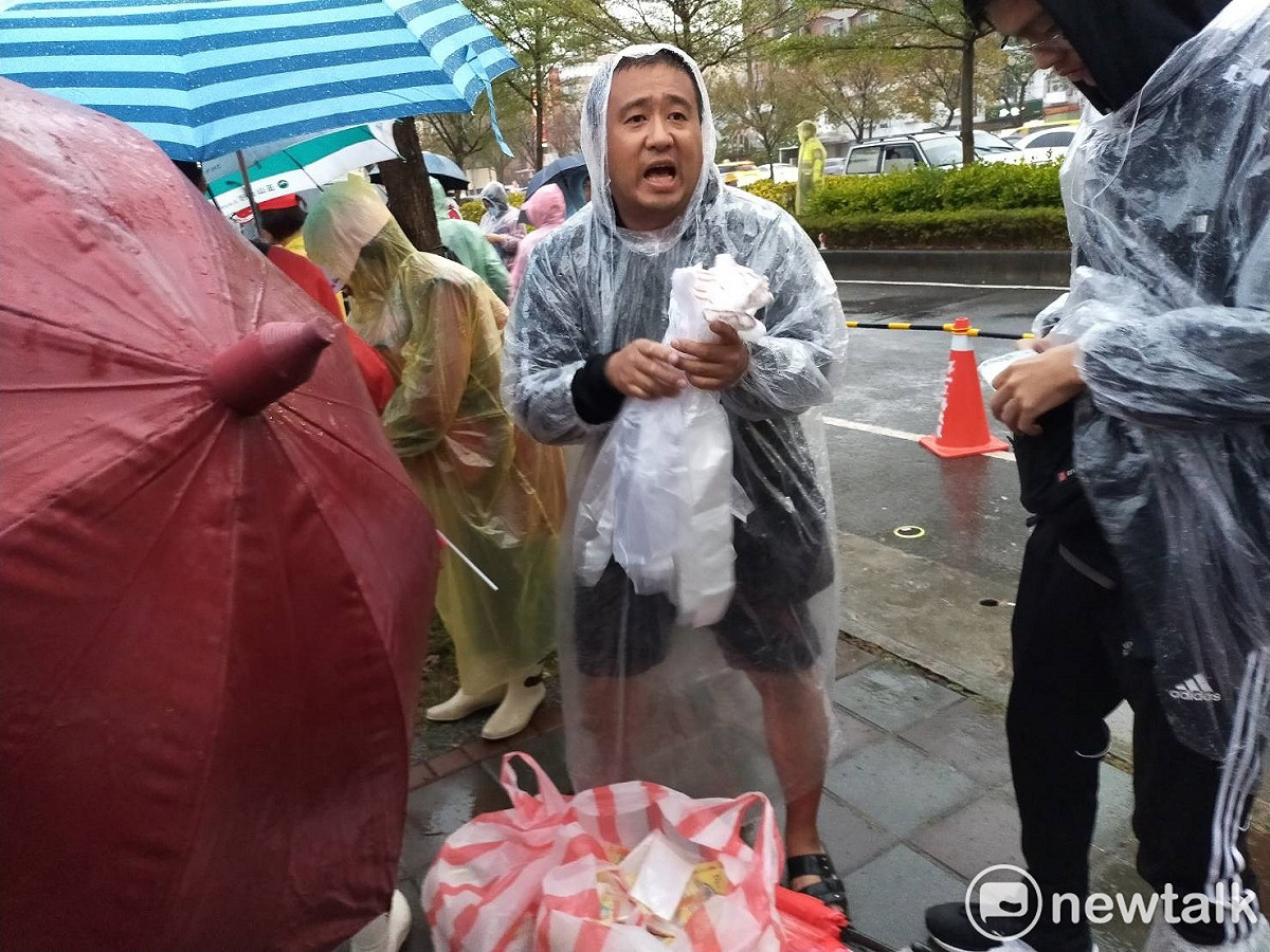 因為大雨加上場地泥濘，許多小販大發下雨財，賣起雨衣與鞋套。 圖：唐復年/攝