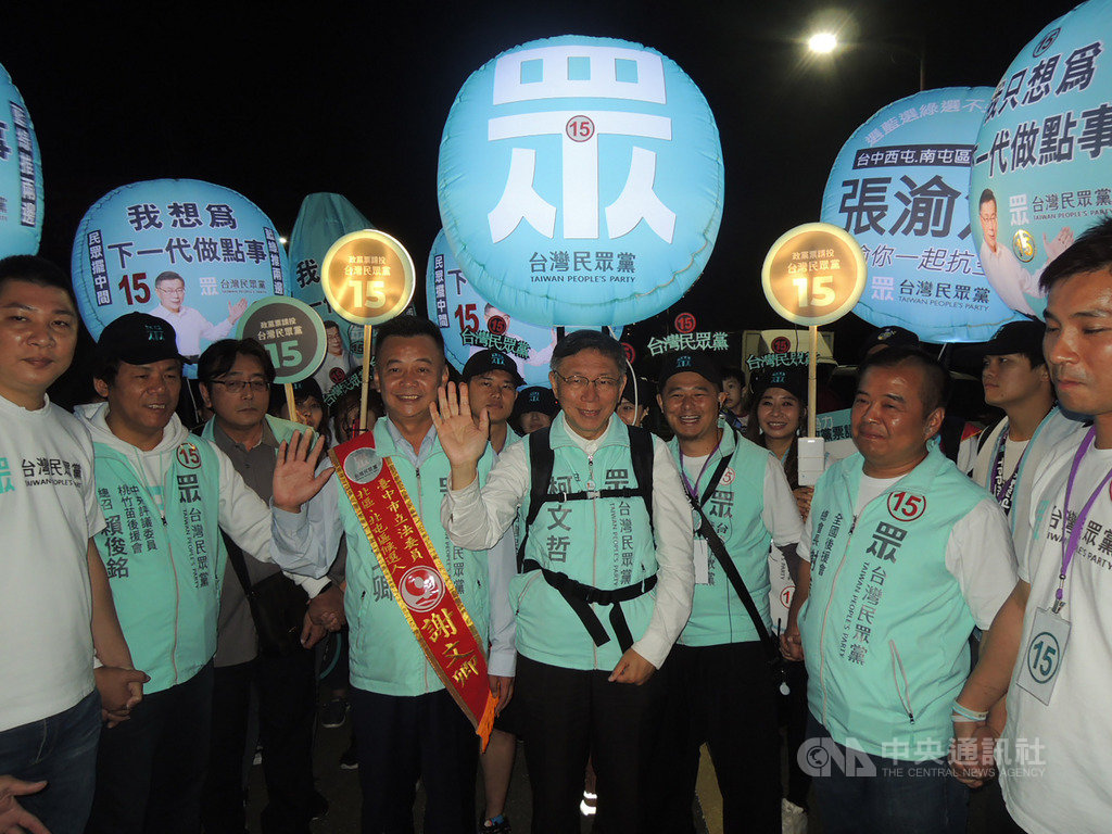 台灣民眾黨4日晚間在台中市北屯區太原夜市舉辦造勢晚會，黨主席柯文哲（中）揹起宣傳氣球，在支持者簇擁下進場，為立委候選人站台。 圖／中央社提供