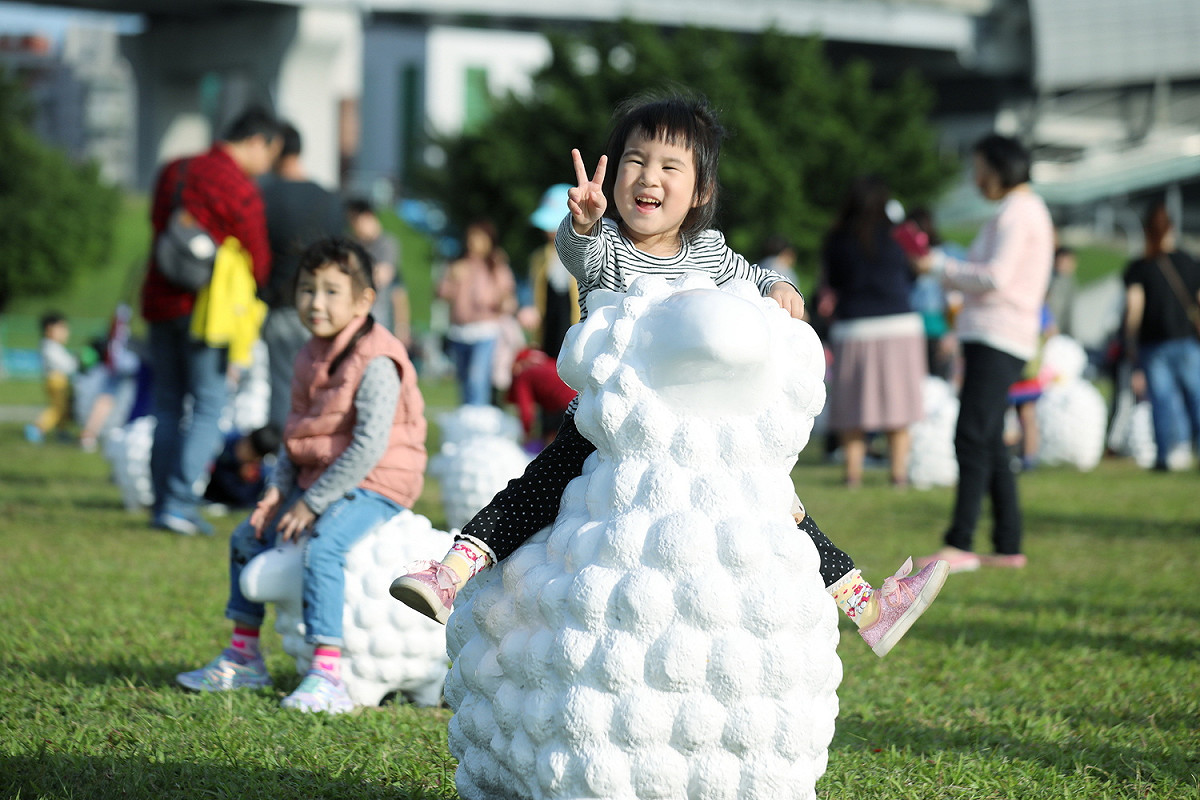 三重捷運站外的大都會公園現正展出藝術家蔡坤霖《詩步領羊》的裝置藝術作品，60隻羊咩咩錯落在綠色草坪上，非常療癒。  圖：新北市政府／提供