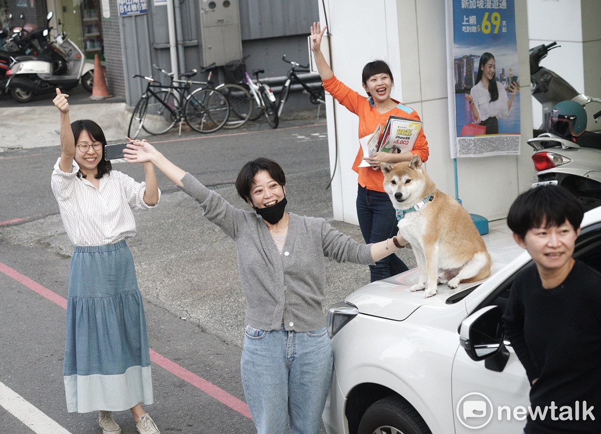 一些年輕人在路旁揮手。 圖：張良一/攝