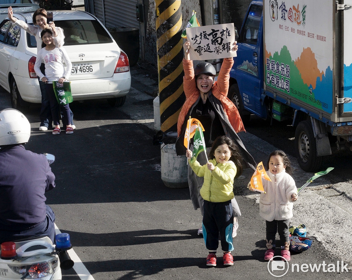 一位媽媽在台中神岡帶著兩位女兒為小英加油，她高舉「光復高雄重返榮耀」手舉牌。 圖：張良一/攝