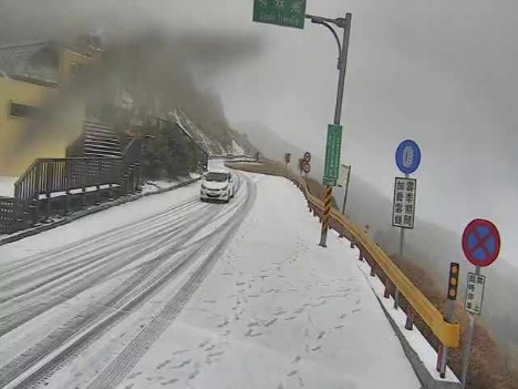 合歡山在13日清晨降下瑞雪，山莊雪厚標尺、台14甲32K975公尺附近已有積雪，車輛必須加掛雪鍊才能通行。 圖：翻攝自即時影像監視器臉書影像
