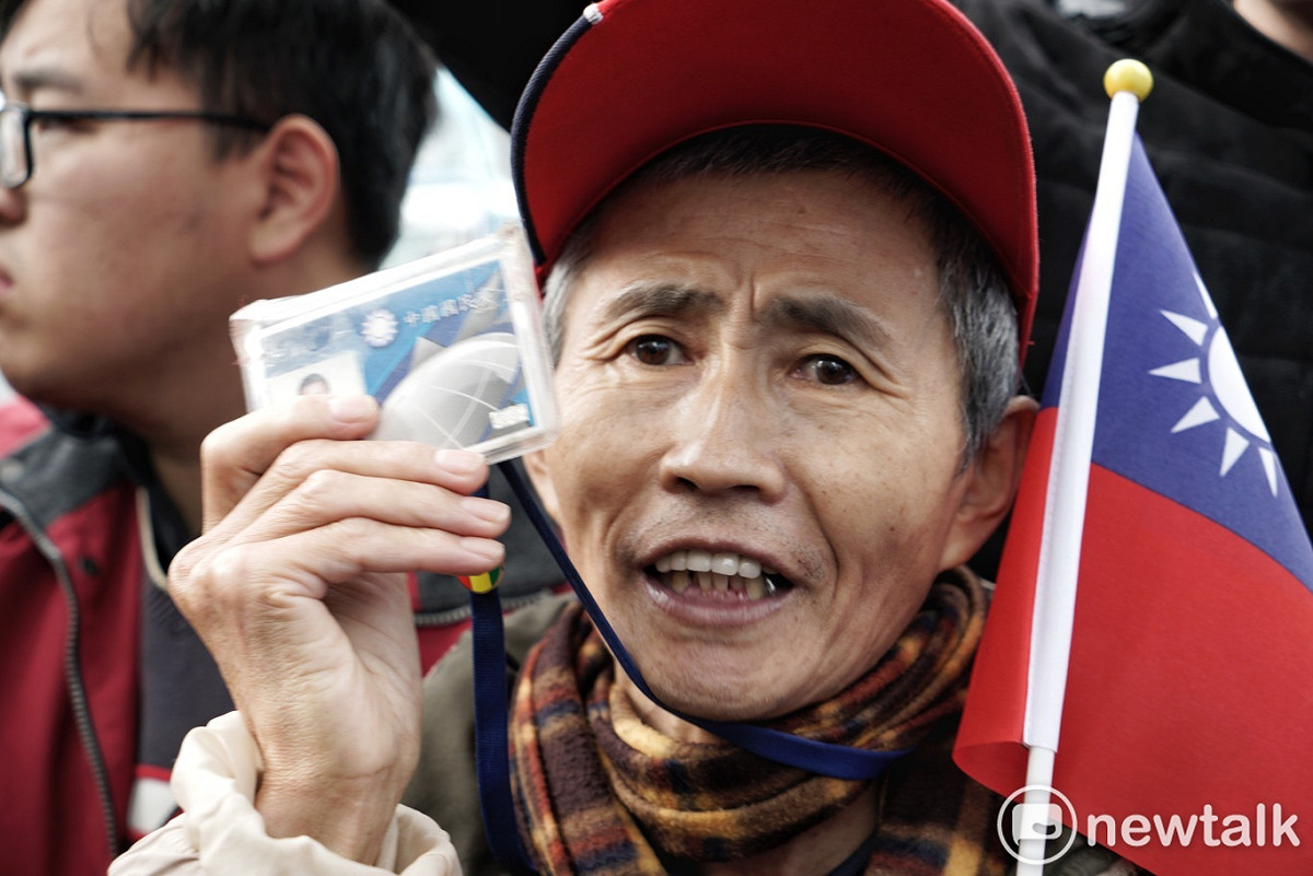 一位老國民黨員在國民黨中央秀出國民黨黨證和國旗。 圖：張良一/攝