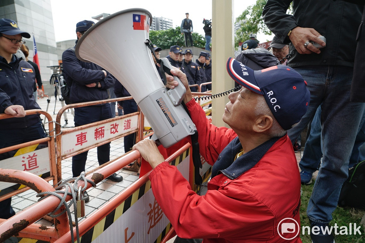 空軍官校桃園校友會的一位成員將喇叭對著國民黨中央黨部。 圖：張良一/攝
