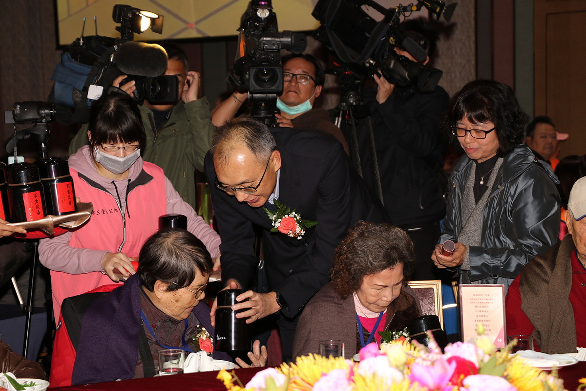 副市長謝政達和社會局副局長許秀能代表侯友宜市長致贈長輩悶燒罐。 圖：新北市社會局提供