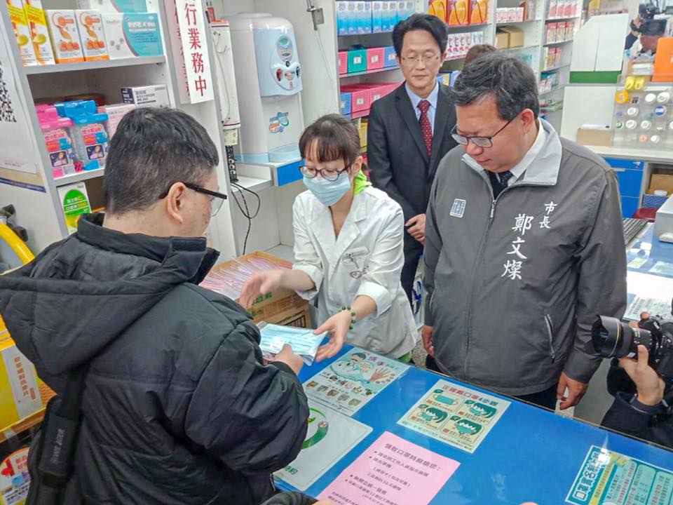 桃園市長鄭文燦（右）6日一早前往桃園市健保特約藥局，觀察口罩實名制上路，民眾持健保卡購買的流程。 圖：翻攝自鄭文燦臉書