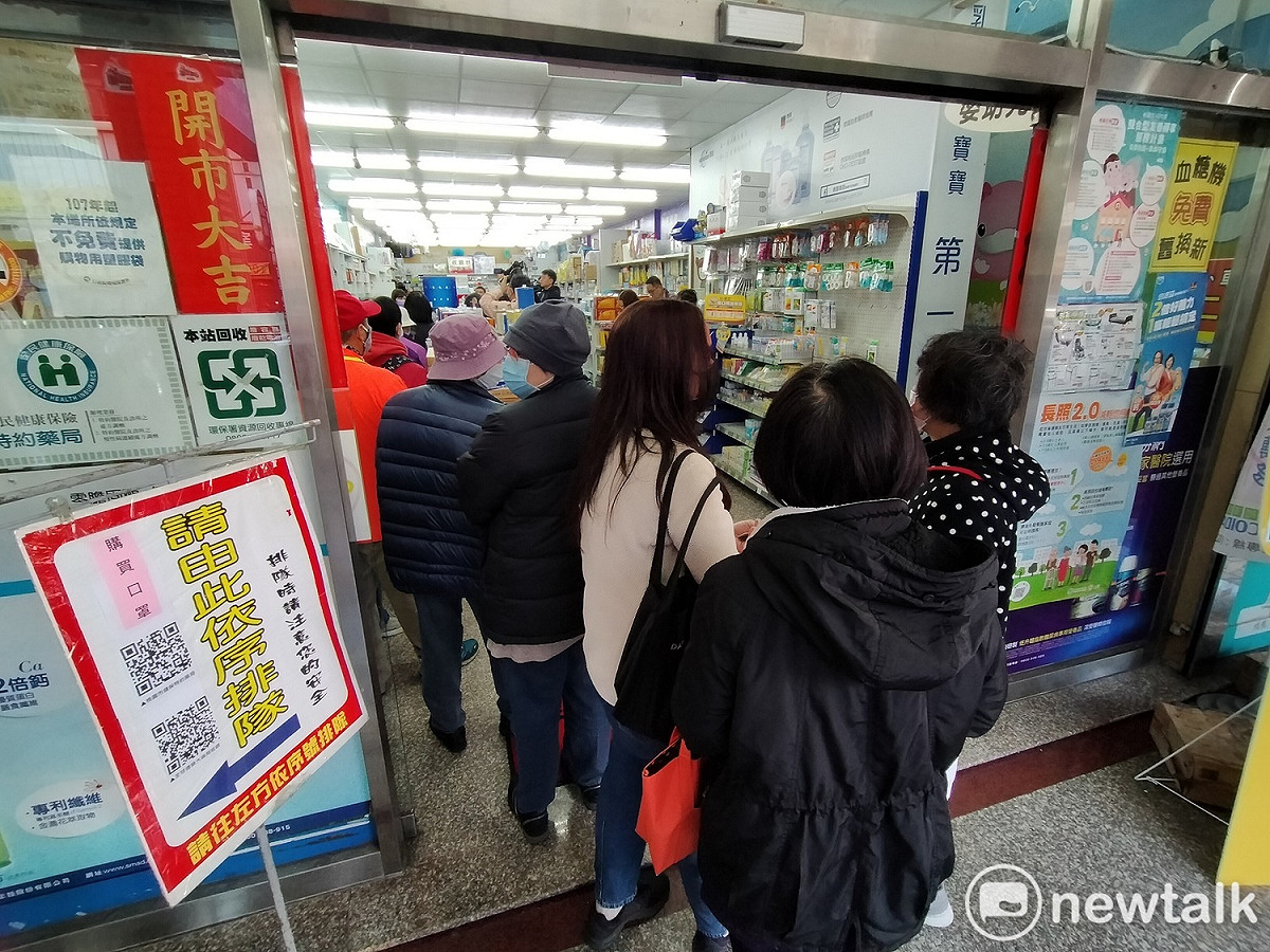 口罩實名制今天上路，健保特約藥局門口全是等著購買口罩的民眾。 圖：林昀真／攝