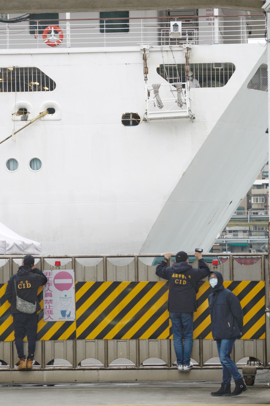 刑警在港區外觀看郵輪靠港作業。 圖：張良一/攝