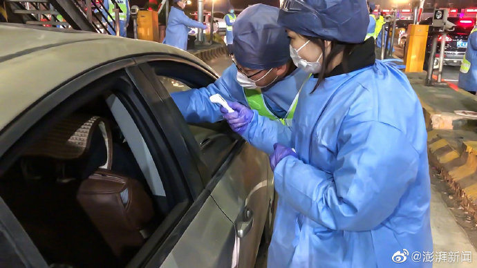 志願者對入滬車輛的司機、乘客進行體溫量測。 圖：翻攝澎湃新聞