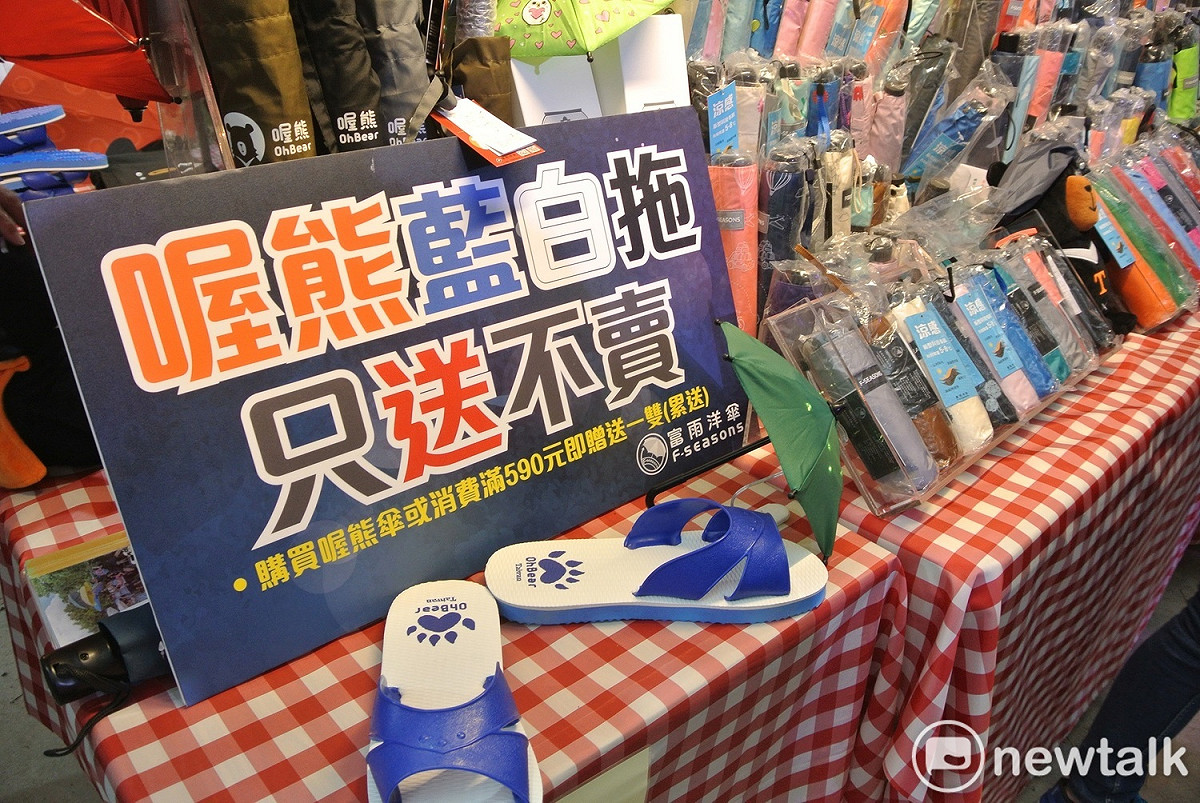 富雨洋傘的公益攤位，喔熊藍白拖只送不賣。 圖：唐復年/攝